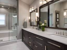 Transitional bathroom blends modern and traditional elements with a neutral palette, stylish vanities, and comfortable lighting for a balanced design.  