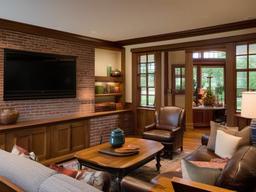 Craftsman living room features built-in wooden bookshelves, a brick fireplace, and handcrafted furniture for a cozy, traditional feel.  